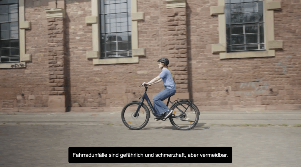 Junge Frau auf dem Fahrrad, die zur Arbeit fährt. Das Bild ist mit Untertiteln versehen, um die Barrierefreiheit unserer eLearnings zu gewährleisten.